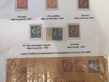 une enveloppe sur laquelle sont collés de nombreux timbres et un bout de papier sur lequel il y a quelque chose d'écrit