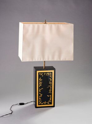 une photo d'une lampe de table noire et dorée avec un abat-jour blanc