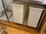 une photo d'une cuisine avec deux poubelles et un grille-pain