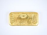 a close up of a gold bar on a white surface