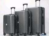 trois bagages empilés les uns sur les autres sur une surface blanche