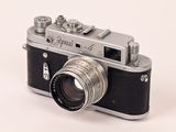 a black and silver camera on a white surface