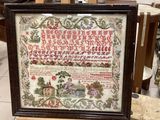 une photo d'une photo d'un échantillon de broderie au point de croix dans un cadre