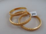 three gold rings with a price tag on them sitting on top of a table