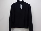 a black sweater hanging on a hanger on a wall