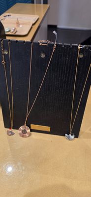 Plusieurs colliers sont exposés sur une table dans une bijouterie.