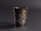 an old silver cup with a flower design on it