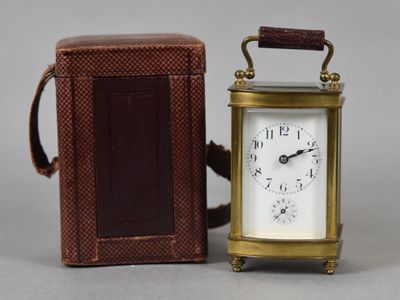 une petite horloge posée à côté d'une petite boîte