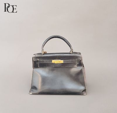 un sac à main noir et argent posé sur une surface blanche