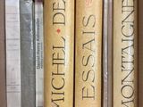three books in a box on a shelf next to each other