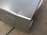 a silver microwave sitting on the floor next to a black cord