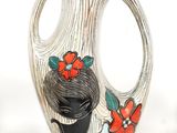 un vase sur lequel est représentée une femme entourée de fleurs