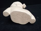 a small white figurine of a dog on a black surface