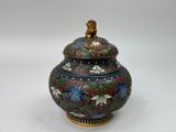 a vase with a lid that has a lion on it