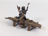 a statue of a man riding a dragon on a wooden bench