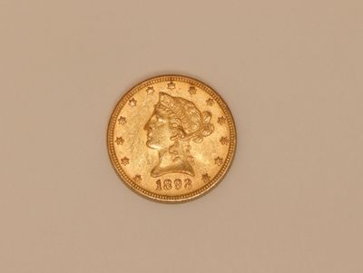 a close up of a gold coin on a white surface