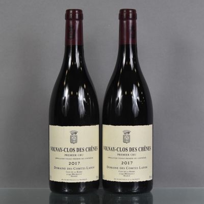 two bottles of red wine sitting on top of a glass table