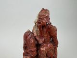 a statue of a man sitting on top of a chair