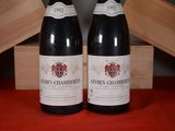 two bottles of wine sitting on a table next to each other