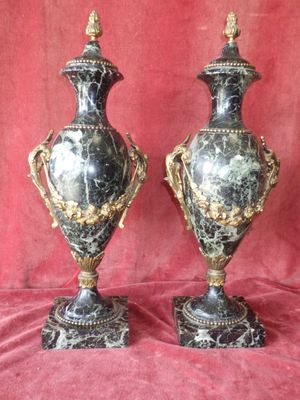 paire de vases anciens noirs et dorés sur fond rouge