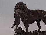 a statue of a dog that is standing on a log