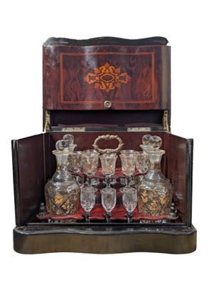 a wooden case with a lot of glassware in it