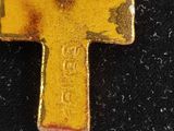 a yellow cross on a black surface with a chain around it