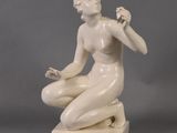 statue of a woman sitting on a marble base with her hands in her pockets