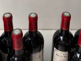several bottles of wine are lined up in a row on a counter