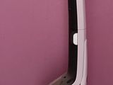 a black and white chair sitting against a pink wall