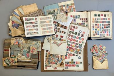 beaucoup de timbres posés sur une table, à côté d'un livre