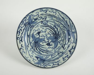 assiette bleue et blanche ornée de deux oiseaux dans un motif en spirale