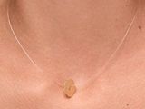 a close up of a woman wearing a necklace with a heart on it