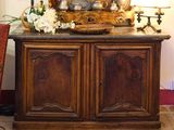 une armoire en bois surmontée d'un miroir, dans une pièce