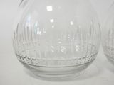 pair of clear glass vases sitting on top of a white table