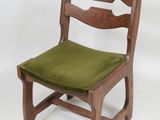 a wooden chair with a green cushion on top of it