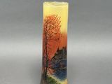 un vase avec un tableau posé sur une table