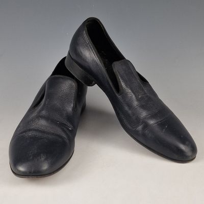 pair of men ' s black leather slippers on a white surface