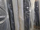 many mattresses wrapped up in plastic bags in a warehouse