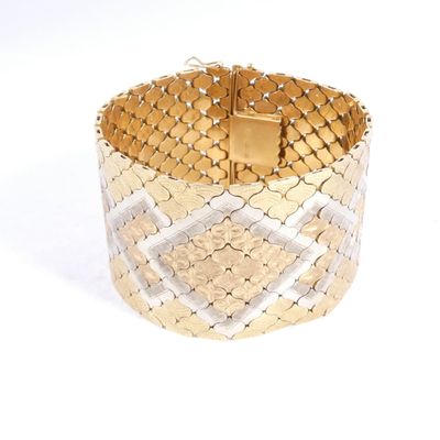 un gros plan d'un bracelet en or et en argent sur fond blanc