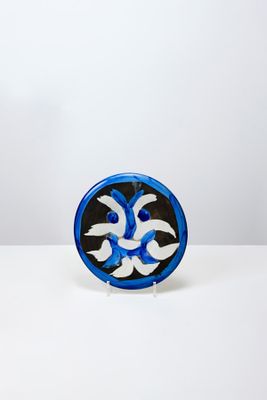 un petit objet bleu et blanc posé sur une surface blanche