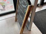 une affiche placée sur le trottoir devant un restaurant