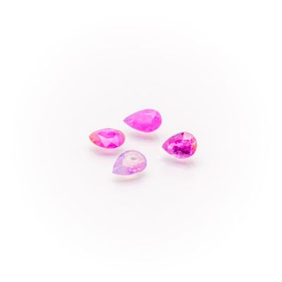 a group of three pink and white crystals on a white surface