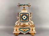 une horloge blanche et bleue posée sur un socle, sur une surface grise