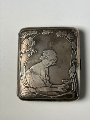 un étui à cigarettes ancien en argent représentant une femme assise par terre