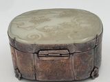 an image of a round box with a carved design on it