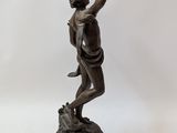 bronze statue of a boy on a pedestal with his arms outstretched