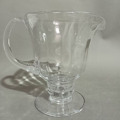 a clear glass pitcher sitting on a white surface