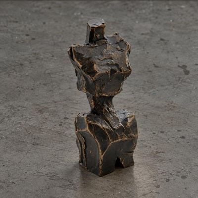 une sculpture représentant un homme assis sur un rocher