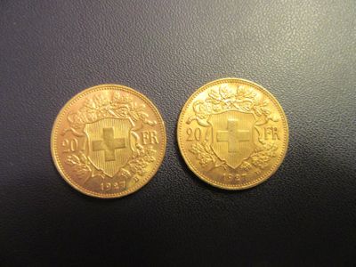 deux pièces d'or posées sur une surface noire